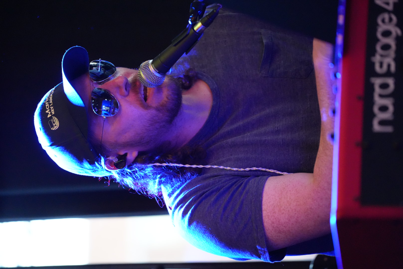 Vocalist with cap and sunglasses at the mic