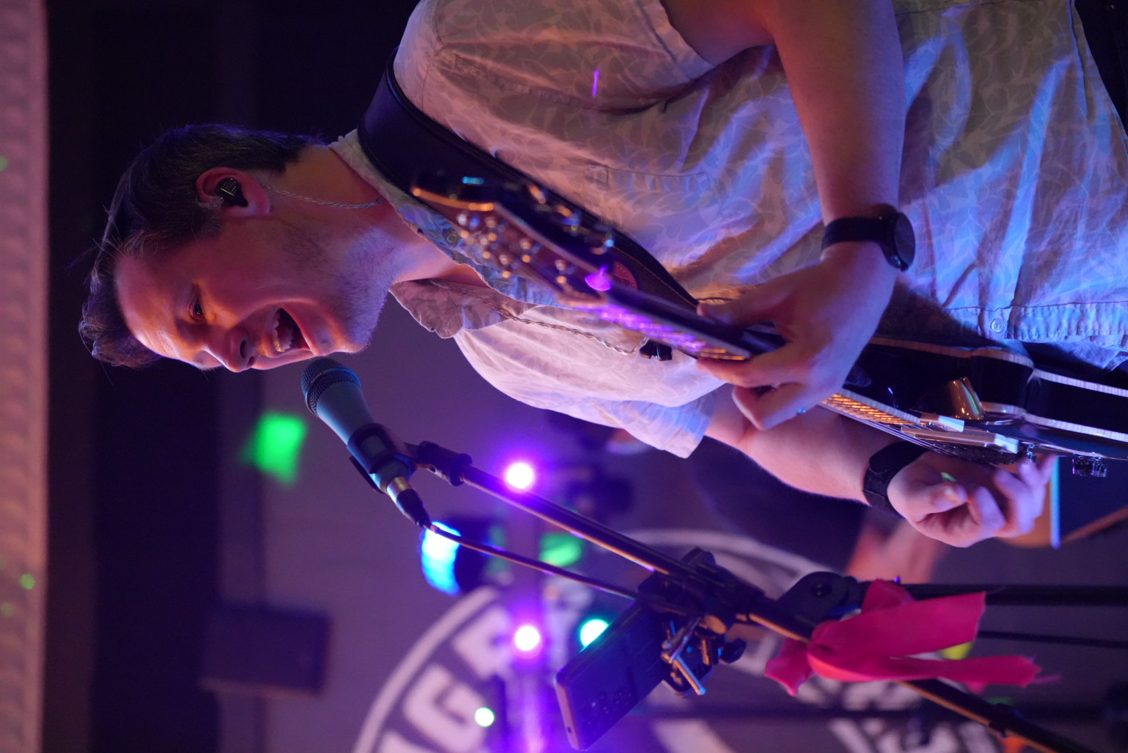 Guitarist at mic with colorful stage lights